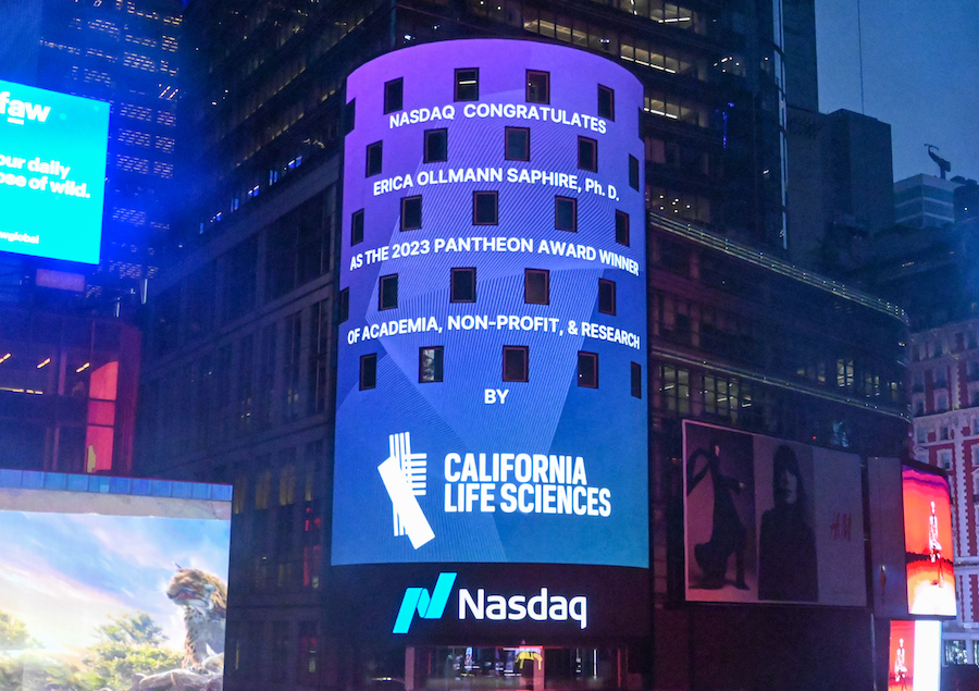 An image of the illuminated Nasdaq sign at night. The text on the sign reads "Nasdaq congratulates Erica Ollmann Saphire, Ph.D., as the 2023 Pantheon Award Winner of Academia, non-profit, and research by California Life Sciences