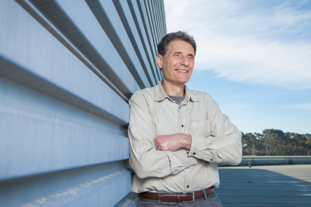 Portrait photo of Dr. Kronenberg. He is standing outside with his arms crossed